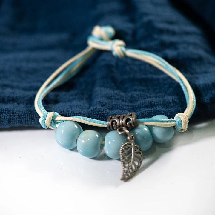 bracelet featuring Blue ceramic beads on a Blue and white stand.