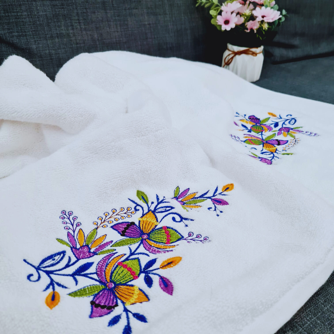 Close-up of colorful floral embroidery on a white cotton bath towel, best quality in Dubai.