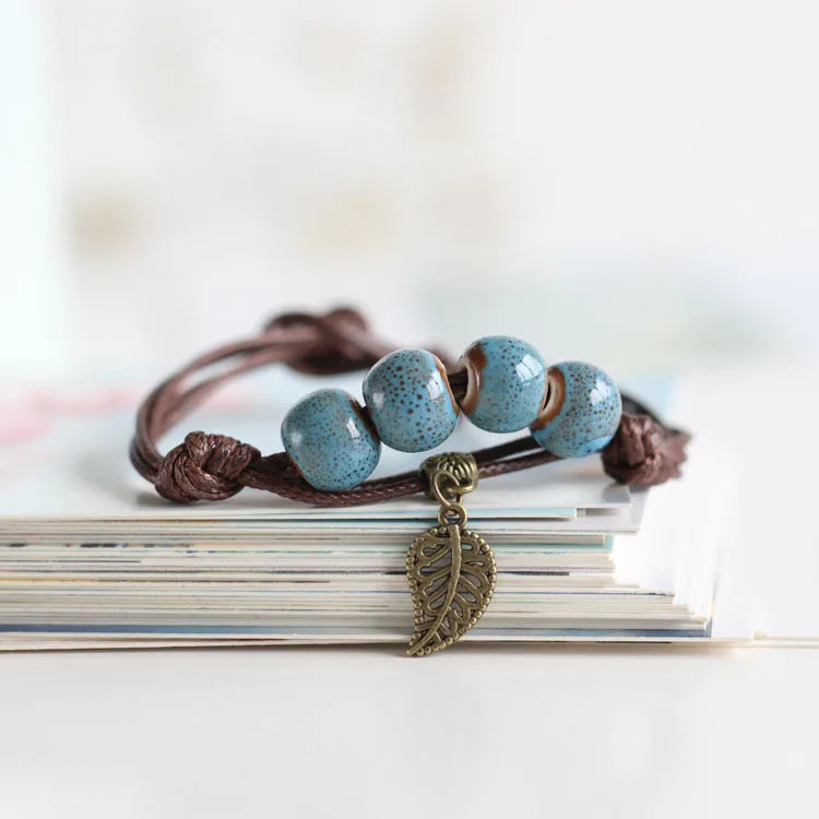 Handcrafted bracelet with ceramic blue beads and a vintage copper leaf charm.