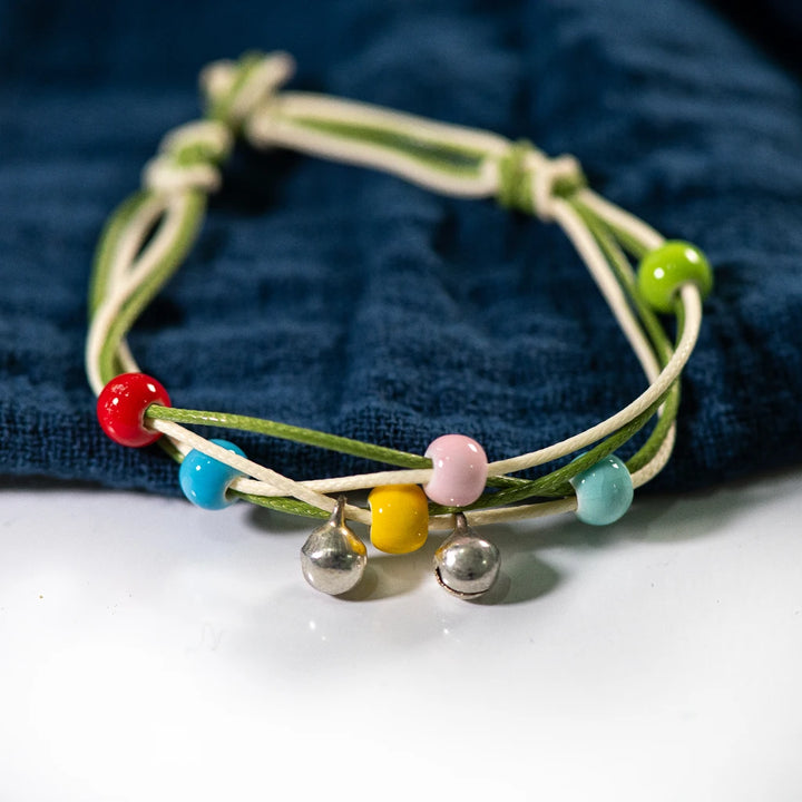 bracelet featuring multicolored ceramic beads on a Green and White strand.