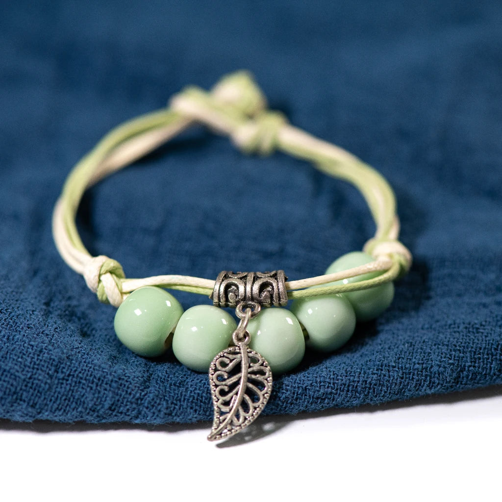 fashionable ceramic bracelet with a mix of elegant beads and a leaf charm.